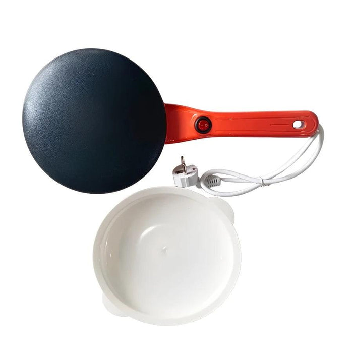 A black electric crepe maker with a red handle, shown with its power cord and a white mixing bowl.