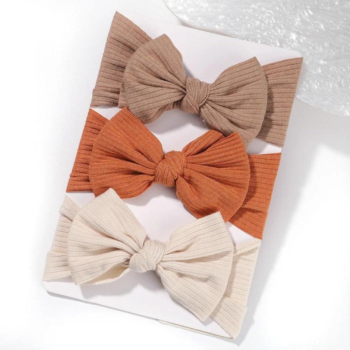 A set of 3 Baby Bow Headbands with different colors.