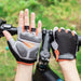 Gloves being used on a bicycle. The gloves have a gray and black design with orange accents, providing grip and comfort for cycling.