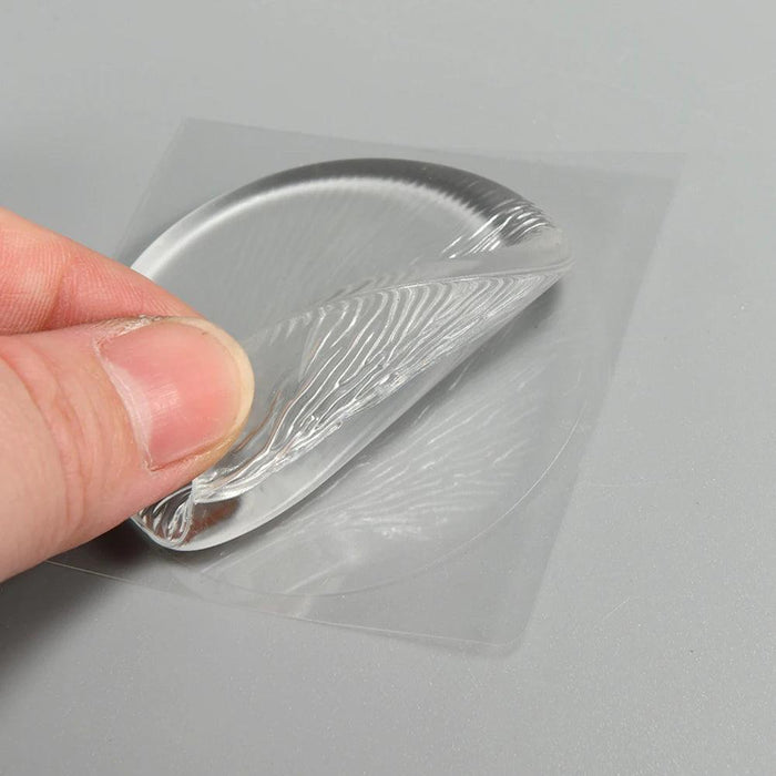 A close-up of a hand peeling off a clear silicone protector from its adhesive backing, showing its flexibility.