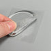 A close-up of a hand peeling off a clear silicone protector from its adhesive backing, showing its flexibility.