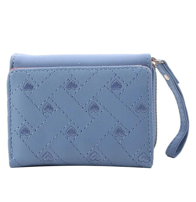 Closed blue wallet with a quilted pattern, showing the front view with a wrist strap and zipper.