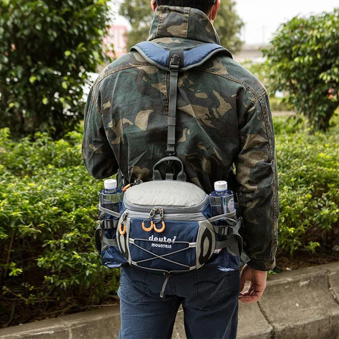 The waist pack is worn by a person, showcasing its fit and functionality in an outdoor setting. The pack is securely attached around the waist, with adjustable straps, and is equipped with two water bottles, emphasizing its practicality for staying hydrated during outdoor activities.