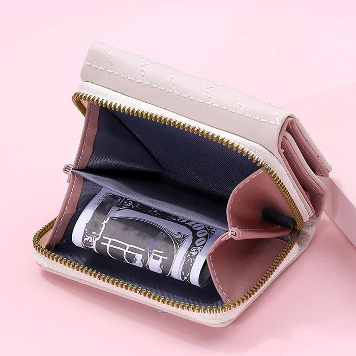 Open beige wallet with a zippered compartment, showing cash inside, on a pink background.