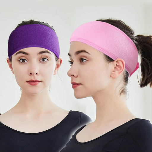 Two women wearing headbands, one in purple and the other in pink.