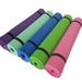 Five yoga mats rolled in colors: purple, blue, green, pink, and turquoise on a white background.