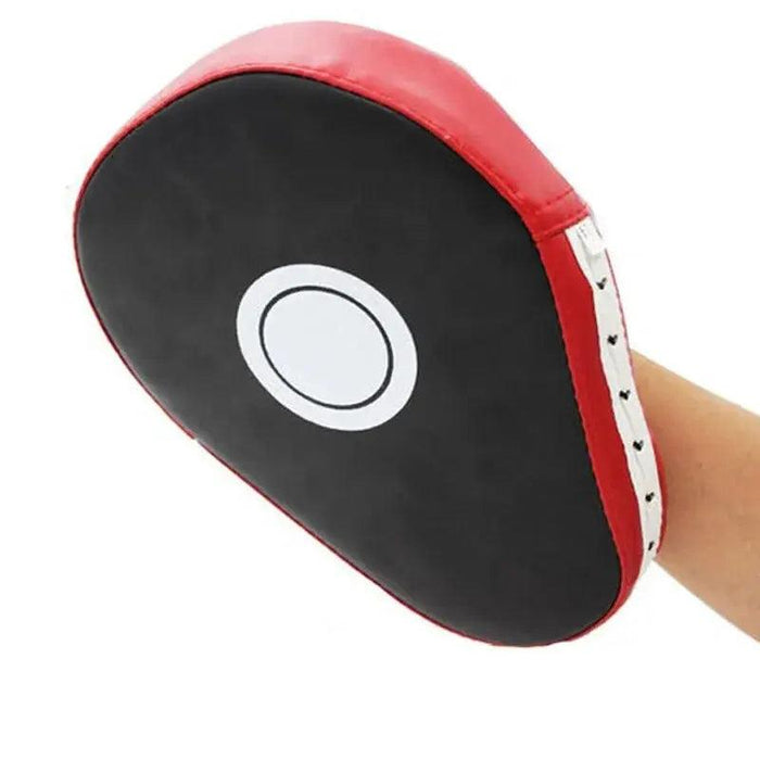 A boxing punching pad is held in a human hand.