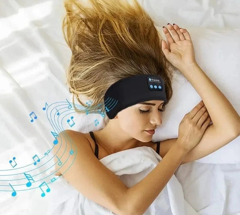 A woman with long blonde hair is sleeping on her side in bed, wearing a black headband with built-in Bluetooth headphones, indicated by musical notes emanating from the headband.