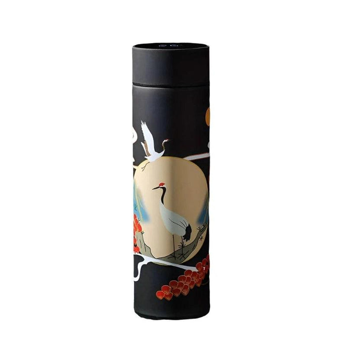 A tall, cylindrical thermos with a black body, adorned with illustrations of flying cranes and ocean waves. The lid, placed next to the thermos, displays a digital temperature reading of 19°C.