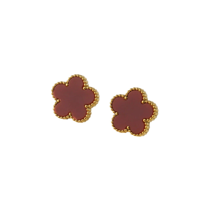 A gold earrings, designed with a flower-shaped pendant with a red center.