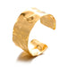 Wide gold cuff bracelet with a smooth, polished finish, displayed on a white background.