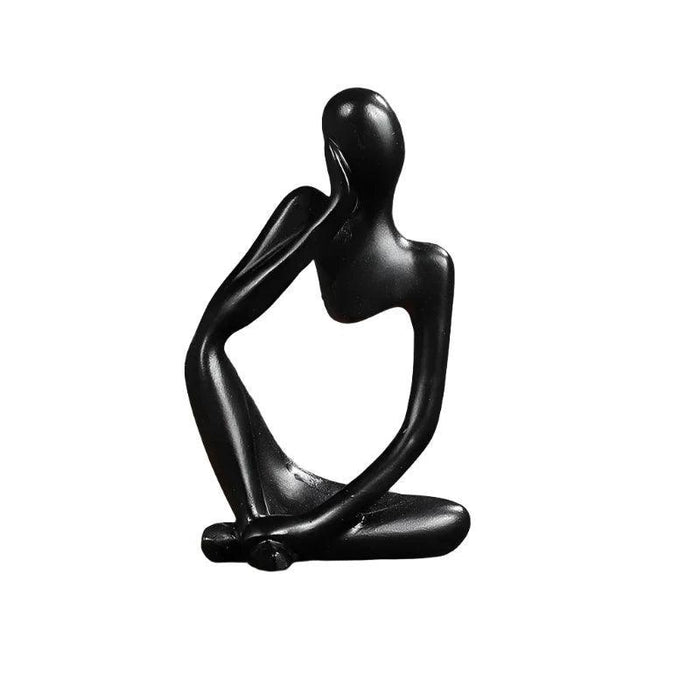 Black minimalist abstract sculpture of a figure sitting cross-legged with one arm resting on the head.