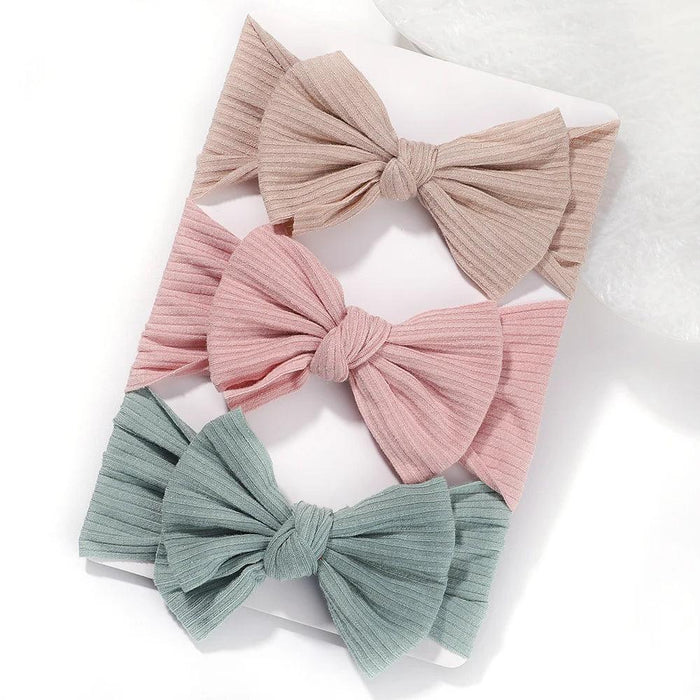 A set of 3 Baby Bow Headbands with different colors.