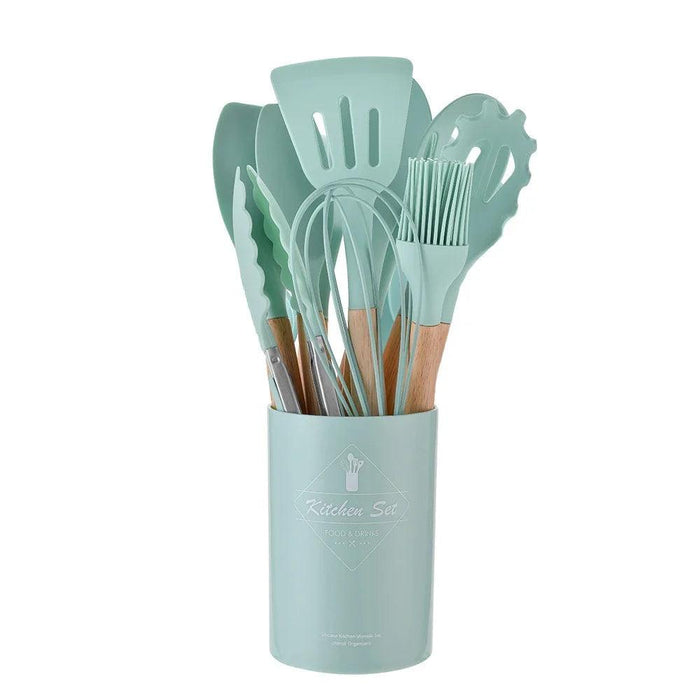 Mint green kitchen utensil set with wooden handles in a matching holder.