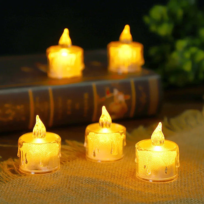 LED tea light candles designed to mimic the appearance of real candles with melted wax drips. The candles emit a warm yellow light and are arranged on a book, creating a vintage and intimate ambiance.