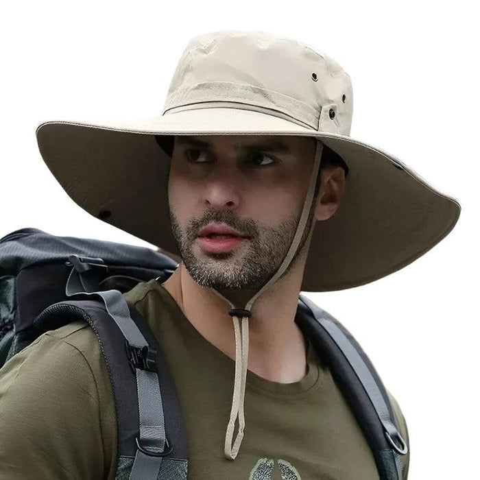 Man wearing a wide-brimmed khaki sun hat while hiking, with a backpack on his shoulders. The hat provides sun protection, perfect for outdoor activities such as hiking and camping.