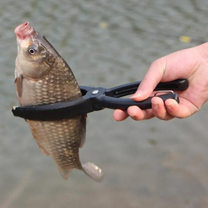 The gripper holding a fish by the mouth, showcasing its use in fishing.