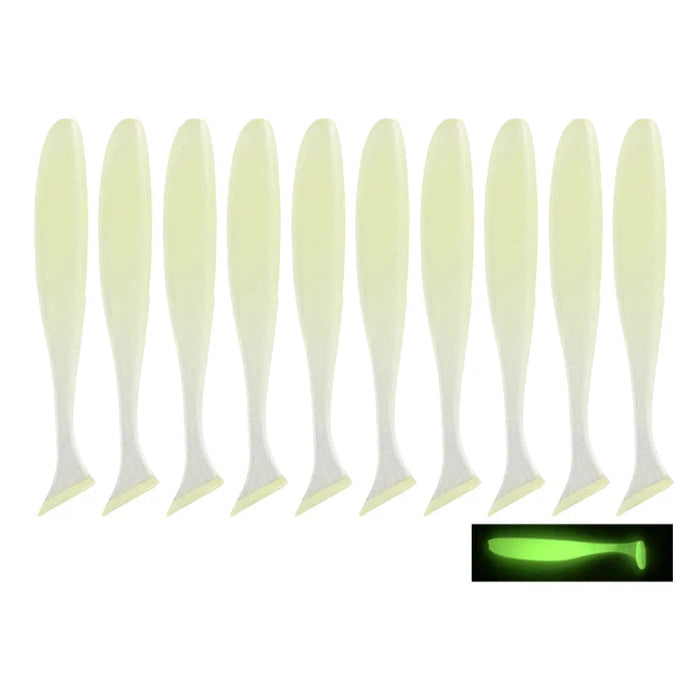 A row of ten soft plastic paddle tail fishing lures in a pale color that glows bright green in the dark, with an inset image showing the glowing effect.