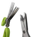 Two herb scissors, one with green handles and one with blue handles, cutting green onions.