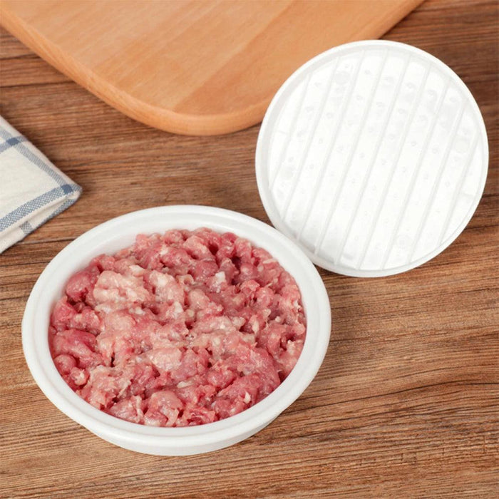 White burger press filled with raw minced meat, positioned on a wooden surface.