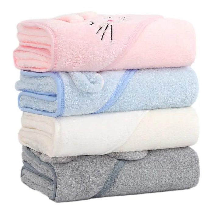 A neatly stacked pile of baby towels in various pastel colors. From top to bottom, the colors are pink, light blue, white, and grey. The top towel has an embroidered design resembling a cat's face.