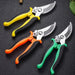 Three pairs of pruning shears with yellow, orange, and green handles, arranged side by side on a dark surface.