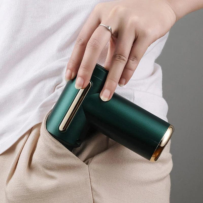 A person is holding the compact Fascia Massager, showing that it can easily fit in their pocket. The teal Fascia Massager is partially inserted into a beige pocket.