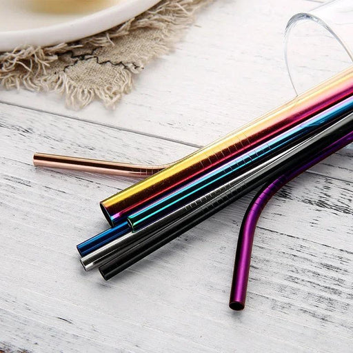 Colorful assortment of metal straws on a rustic wooden surface.