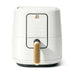 A sleek white air fryer with a gold handle, featuring a digital display and various cooking options.