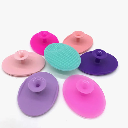 Multiple silicone scrubbers in various colors (pink, purple, green) with suction cups, displayed in a circular arrangement, highlighting the variety.