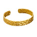  Gold cuff bracelet with a hammered texture, displayed on a white background.