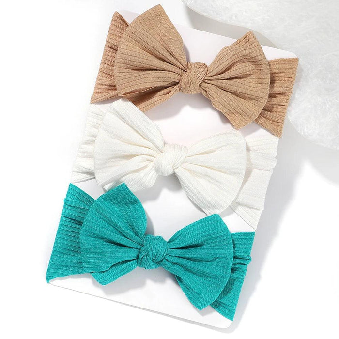 A set of 3 Baby Bow Headbands with different colors.