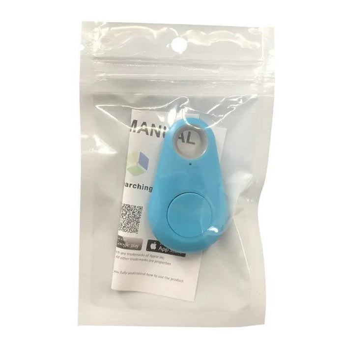 A blue GPS tracker, this one in a more triangular shape, is displayed in a sealed plastic bag with branding and instructions.