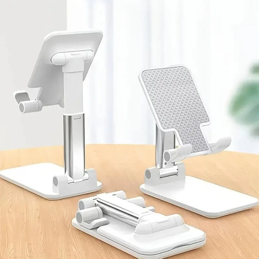 Three white collapsible phone stands, shown in various positions: upright, partially collapsed, and fully collapsed. The stands are on a wooden surface against a light background.