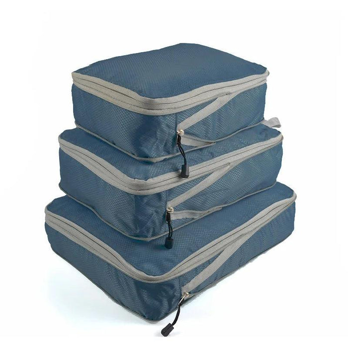 Three blue packing cubes with gray zippers and handles, stacked on top of each other. Each cube has a zipper pull with a black tab.