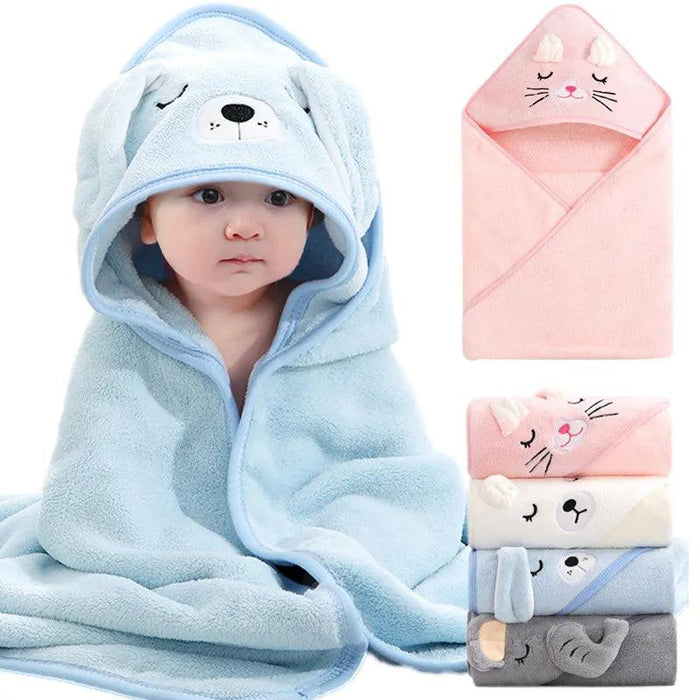 A baby wrapped in a light blue hooded towel designed to resemble a dog. The hood has an embroidered dog face with floppy ears. The baby is sitting with the towel wrapped around them, looking snug and comfortable.