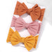 A set of 3 Baby Bow Headbands with different colors.