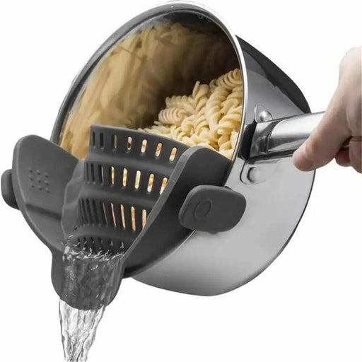 A person pours water from a pot full of pasta with a gray clips that holds the pasta so it doesn't fall and allows the water to escape. Ideal for simple food preparation.