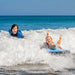 Two children riding waves on bodyboards, enjoying the ocean.