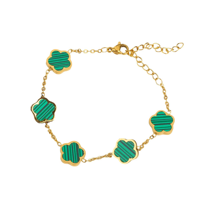 A gold bracelet, designed with a flower-shaped pendant with a green center.