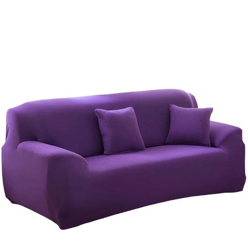 purple sofa covered with a fitted cover and two matching black pillows.