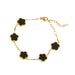 A gold bracelet, designed with a flower-shaped pendant with a black center.