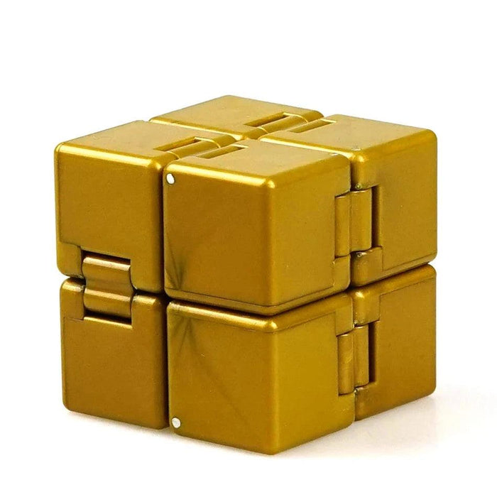 A close-up of a gold Crazy Cube, showing its interlocking blocks and compact form.