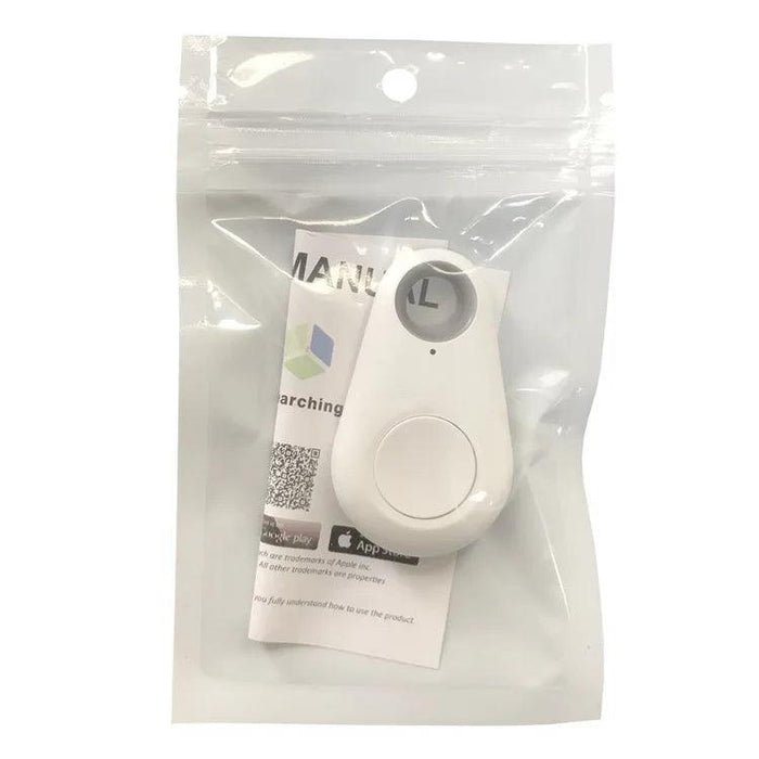 The GPS tracker in white, packaged in a transparent plastic bag. The packaging includes an instruction manual with a QR code visible through the bag. The tracker has a button and a small hole at the top.