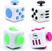 Four white fidget cubes with colored buttons and dials in blue, black, green, and pink.