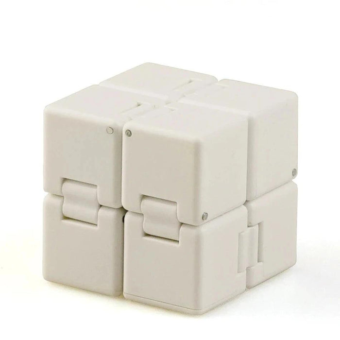 A close-up of a white Crazy Cube, showing its interlocking blocks and compact form.