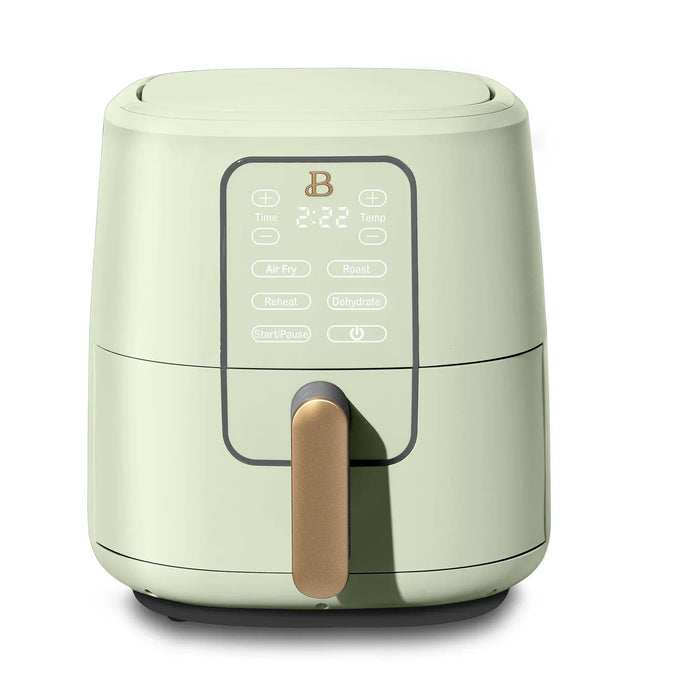 A sleek green air fryer with a gold handle, featuring a digital display and various cooking options.