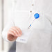 A person holding an ID badge with a blue retractable badge reel attached to their shirt pocket.