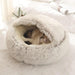 A fluffy, dome-shaped pet bed in light grey with a cat sleeping inside it.