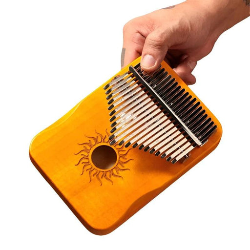 An orange kalimba with a hand holding it